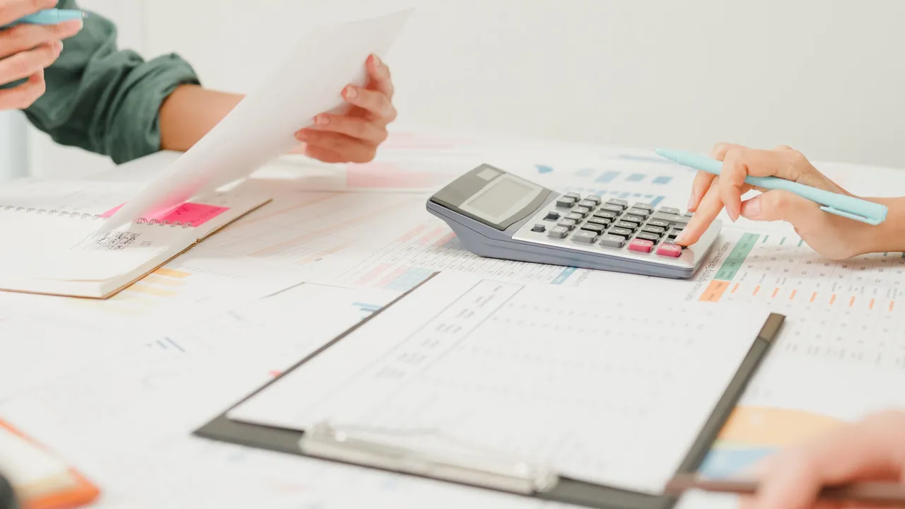 Hands working with calculator and documents