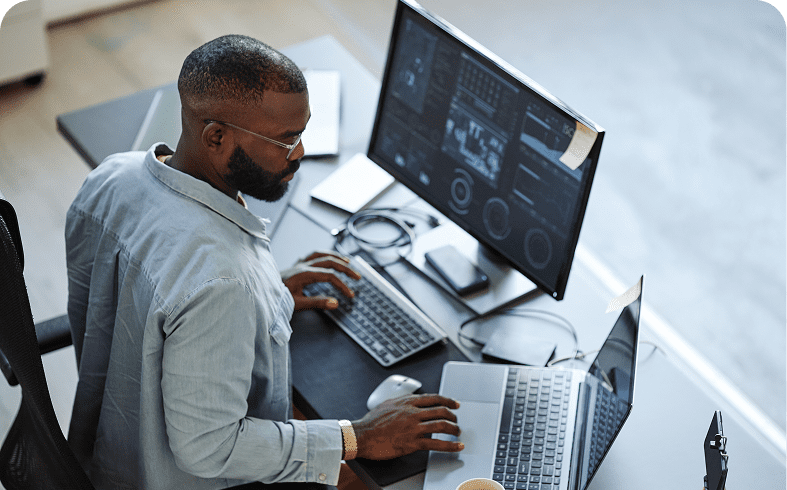 Man working with multiple computer screens