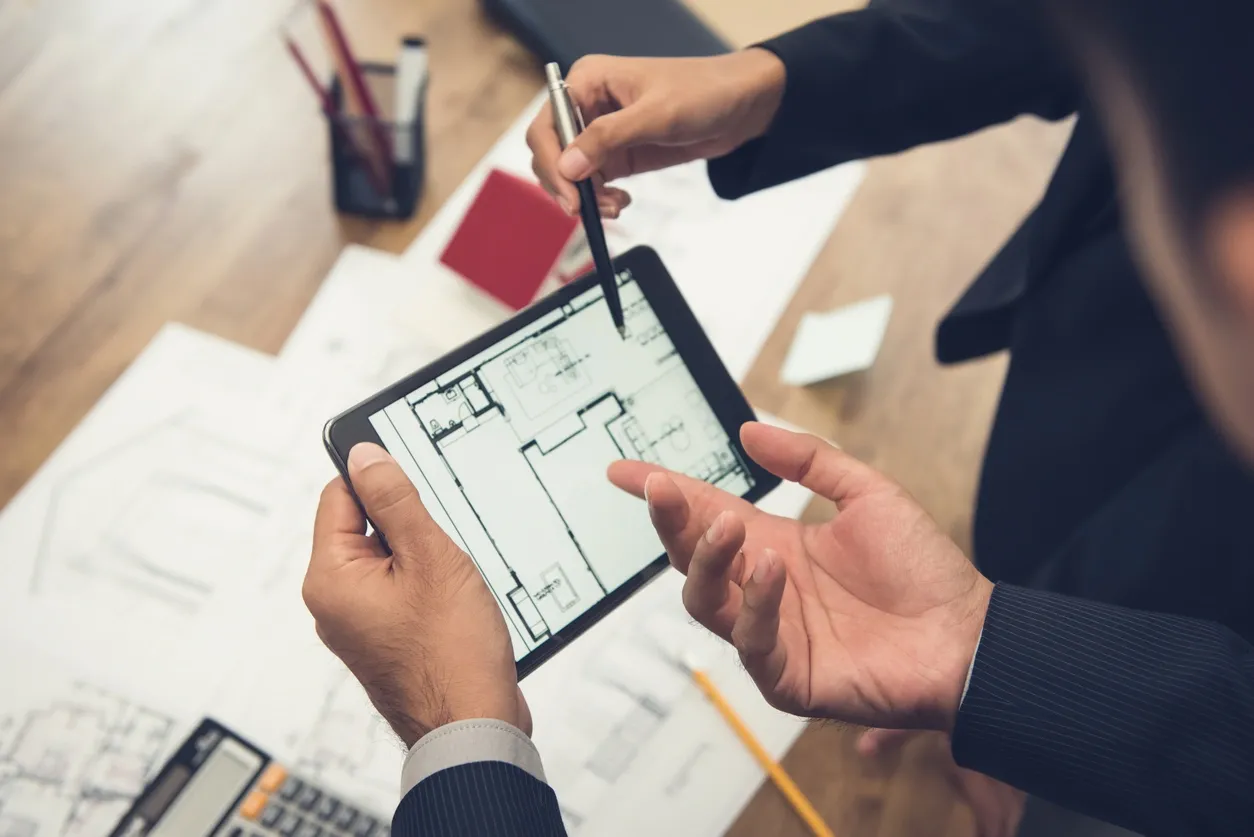 Team discussing architectural designs on tablet