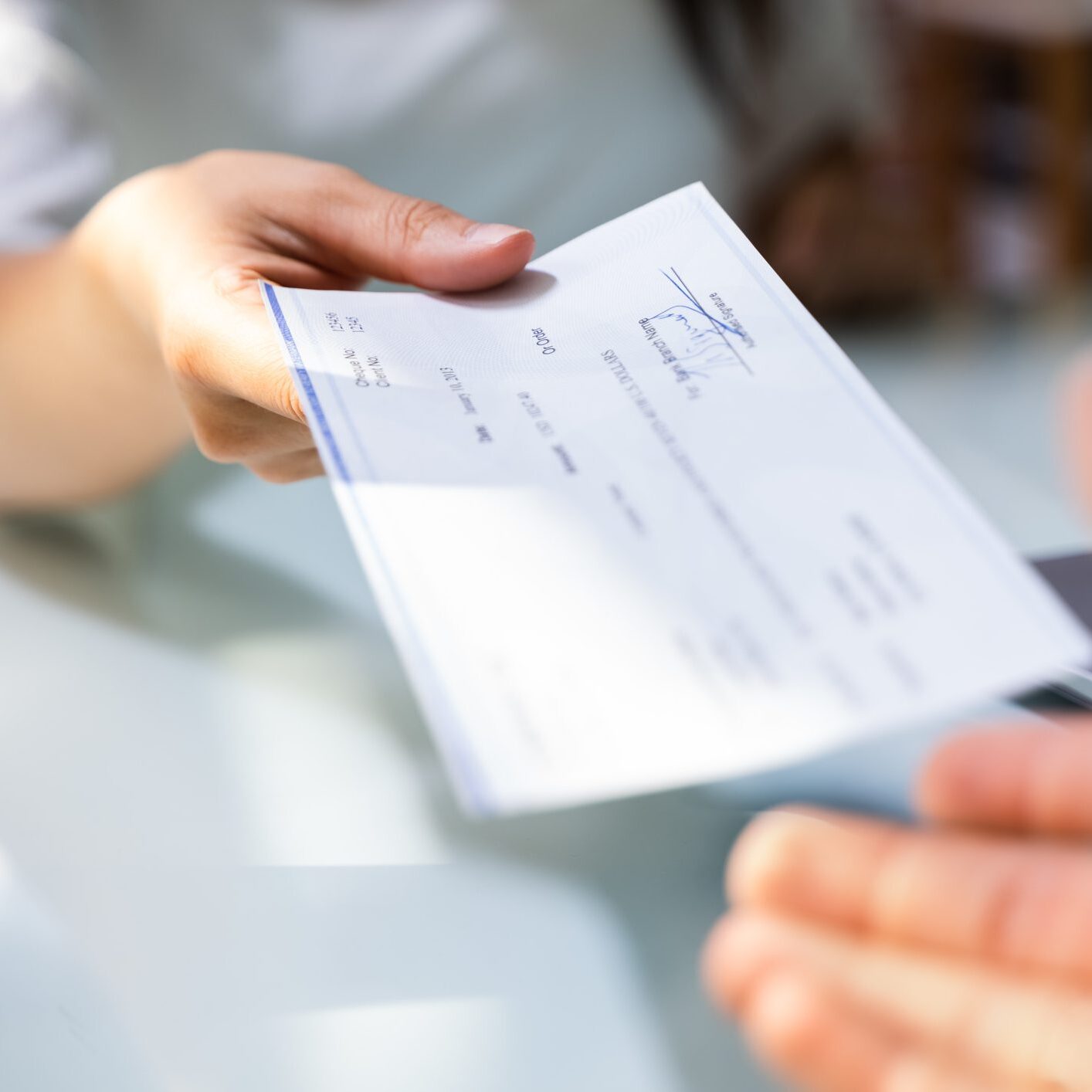 Hand Giving Payroll Compensation Paycheck. Salary Cheque